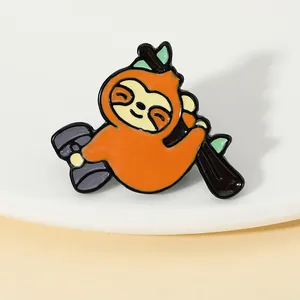 Macro detail of enamel sloth brooch with dumbbell showing polished alloy and vibrant colors