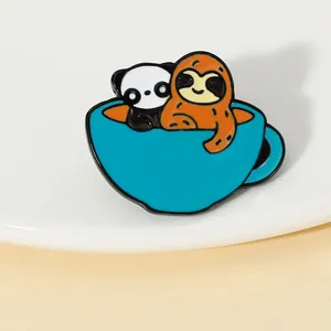 Close-up of a panda and sloth inside a blue coffee cup enamel pin accessory