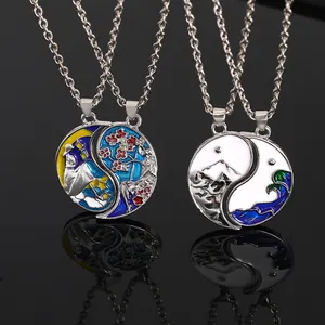 Détail de pendentifs Yin Yang avec soleil lune et paysages sur surface miroir noire