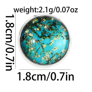 Dettaglio spilla rotonda da 1,8cm con motivo ad albero verde acqua e bordo argento