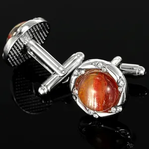 Vue détaillée des boutons de manchette argentés avec pierre marbrée orange et strass