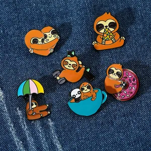 Detail of six creative enamel pins with cute sloth designs on a blue denim background