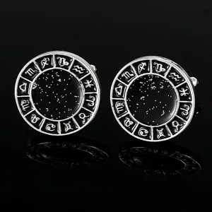 Macro shot of silver circular cufflinks featuring black enamel starry sky and zodiac symbols