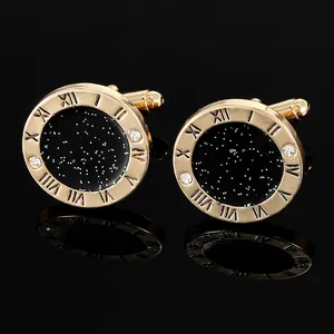 Macro shot of gold round cufflinks with black galaxy enamel and Roman numeral details