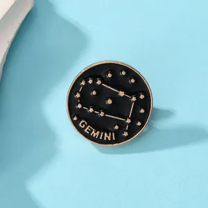 Gros plan sur la broche émaillée noire et dorée avec constellation des Gémeaux