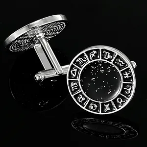 Macro shot of silver zodiac cufflinks with black starry backgrounds and rotating T-bar