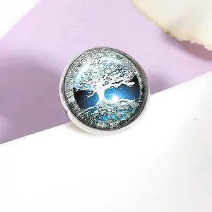 Dettaglio macro di un bottone a pressione da 20 mm con motivo albero della vita blu