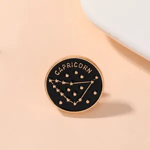 Broche constellation Capricorne en émail noir et métal doré de forme circulaire