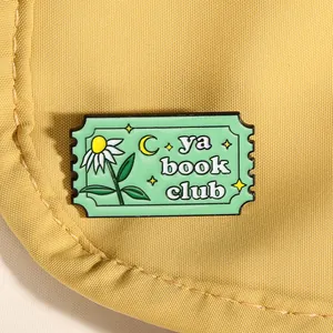 Pin's émaillé vert menthe en forme de timbre avec lettrage ya book club sur toile