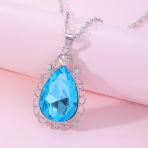 Macro view of blue pear-cut crystal pendant with lace-edged silver metal frame