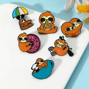 Detailed view of six cartoon sloth enamel pins on a white ceramic tray with floral accents