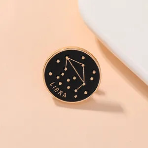 Détail macro du pin's émaillé Balance avec lettrage doré sur fond noir élégant