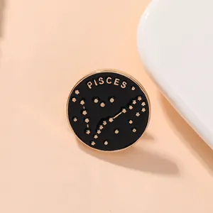 Détail d'un pin's Poissons en émail rond avec lettrage doré et motif de constellation