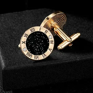 Detail view of round golden cufflinks with Roman numerals and black starry dial texture