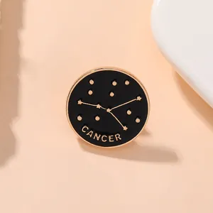Détail de la broche Cancer en émail noir rond avec carte du ciel dorée et lettrage
