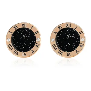 Rose gold round studs with starry black disk, Roman numerals, and crystal accents