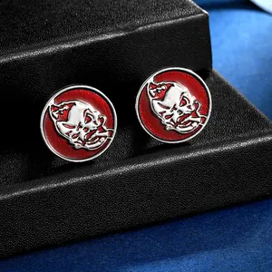 Boutons de manchette punk tête de mort argentée et émail rouge sur boîte noire mate