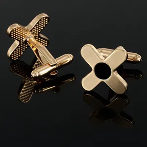 Detailed macro view of gold cross cufflinks showing black round inlay and textured back
