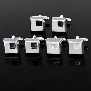 Macro detail of three pairs of silver cufflinks with black, blue, and pink square crystals