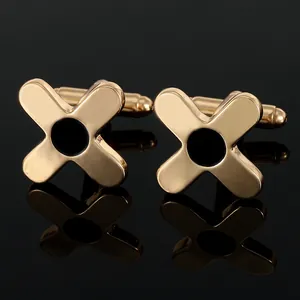 Detailed macro shot of gold cufflinks with black enamel center on a mirrored surface