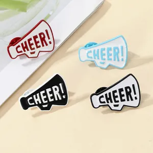 Dettaglio di quattro spille smaltate a forma di megafono con la scritta Cheer