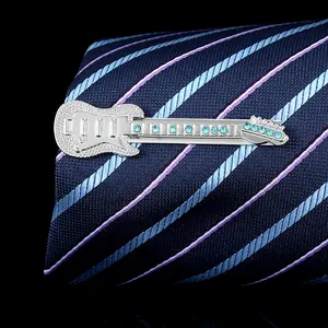 Detail of silver electric guitar tie clip with blue crystals on a navy necktie