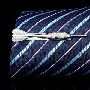 Macro shot of silver dart-shaped tie clip with textured grip on blue necktie