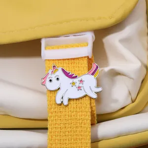 Detail of white unicorn enamel brooch with pink mane and star pattern on yellow strap