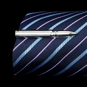Macro view of a silver bullet-shaped metal tie clip on a navy blue striped tie