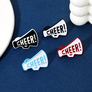 Dettaglio di spillette smaltate a forma di megafono con scritta Cheer e chiusura a farfalla