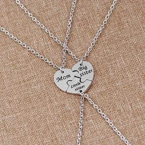 Macro view of three-piece silver heart puzzle necklaces with Mom and Sister engraving