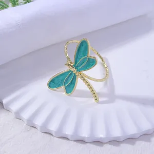 Detail of dragonfly napkin ring with blue enamel wings and spiral gold metal band