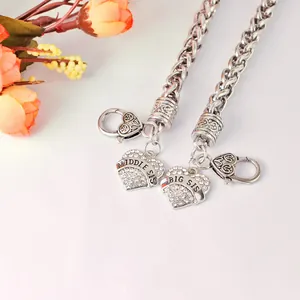 Close-up of heart-shaped Big Sis and Middle Sis pendants with sparkling rhinestones