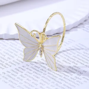 Macro view of a gold-plated butterfly napkin ring with white enamel and sparkling rhinestones