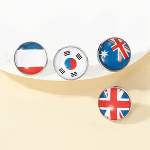 Close-up of round glass national flag badges including UK and Australia on white stand