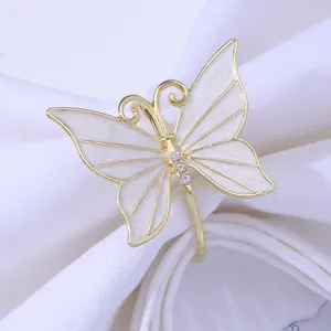 Detail of elegant gold butterfly napkin ring with white enamel and sparkling rhinestones