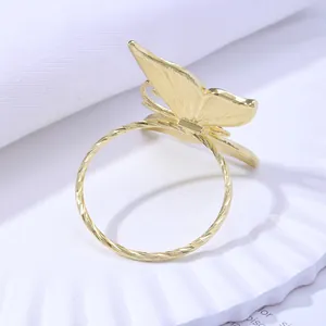 Close-up of golden butterfly napkin ring featuring textured wings and rope twisted band