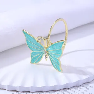 Detail of a golden butterfly napkin ring with light blue enamel and sparkling rhinestones