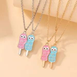 Detail of pink and blue popsicle Best Friends necklaces with cartoon eyes and drip oil finish