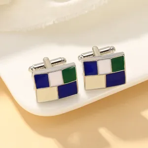 Macro-opname van rechthoekige manchetknopen met blauw en groen geometrisch emailpatroon