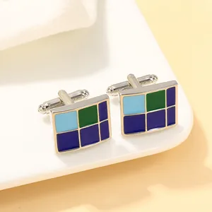 Detail van zilveren vierkante manchetknopen met blauw en groen emaille geometrisch patroon