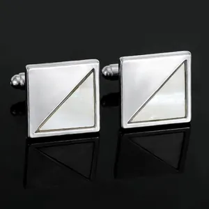 Square silver cufflinks with mother of pearl inlay and mirror finish on a black background
