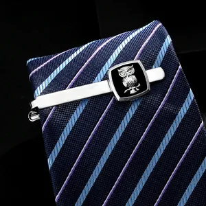 Detalle del relieve de búho plateado en base de esmalte negro para pasador de corbata