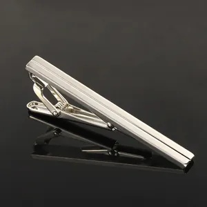 Macro detail of silver business tie clip with polished vertical grooves and spring clamp