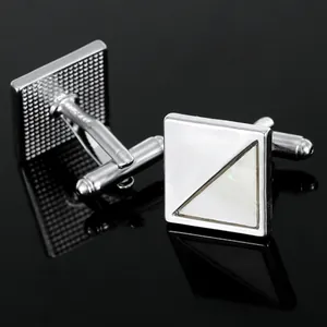 Polished silver square cufflinks with white mother-of-pearl inlay on black mirror background