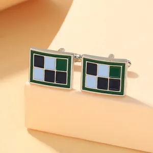 Macro detail van retro rechthoekige manchetknopen met groen blauw geometrisch patroon