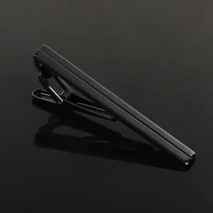 Macro detail of midnight black metal tie clip with dual geometric parallel grooves