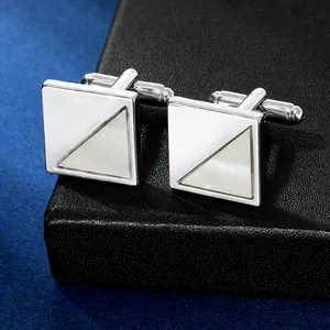 Detail of square silver cufflinks with white mother of pearl inlay on leather texture
