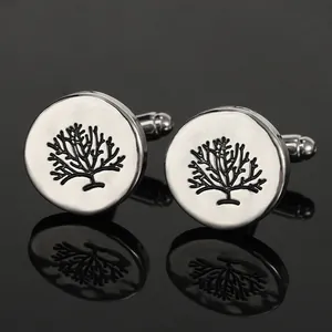 Macro shot of silver round cufflinks featuring black branch patterns and T-back closure