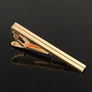 Macro view of polished gold business tie clip with parallel grooves and reflection